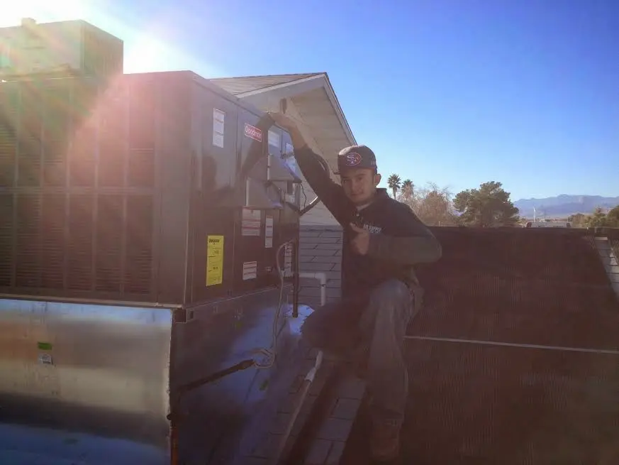 HVAC technician performing HVAC Inspection on a rooftop unit in Coachella